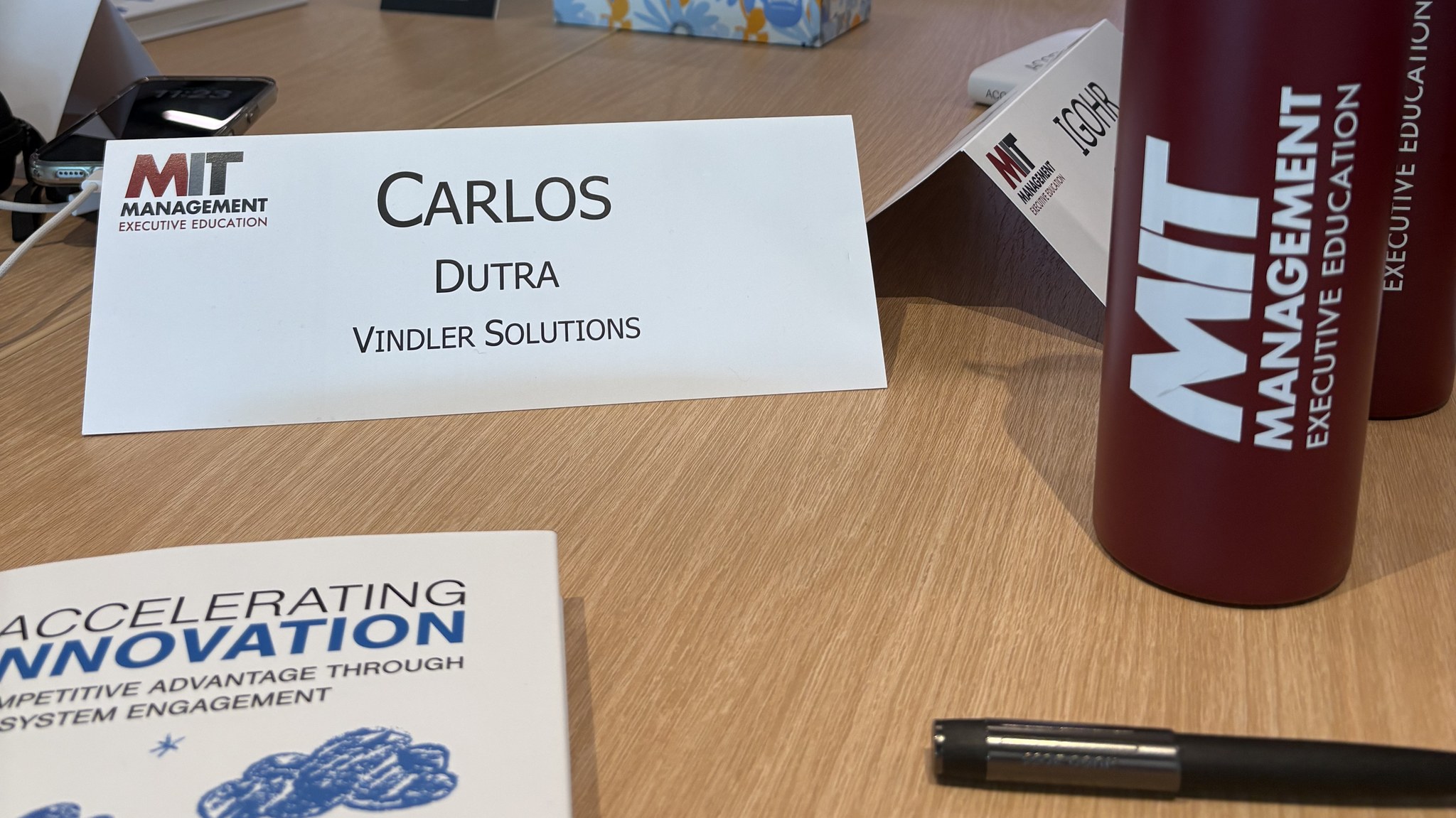 Carlos Dutra's desk name card at MIT Sloan Executive Education, showing his name and Vindler Solutions, in the Leading the AI-Driven Organization classroom